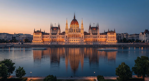 The Hungarian Parliament Building in Budapest at golden hour, reflected in the Danube.